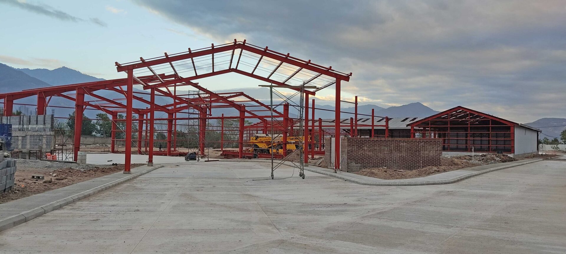 Obra de construcción en Sanarate, Guatemala. Estructura metálica de bodega sobre piso de concreto industrial ejecutado por CCM para Distribuidora Los Cipreses.