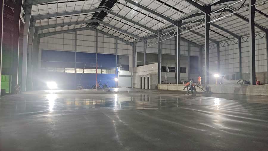 Piso industrial de concreto con acabado liso y brillante en Ofibodegas Inversiones Inmobiliarias Marsella, Guatemala. Iluminación nocturna.