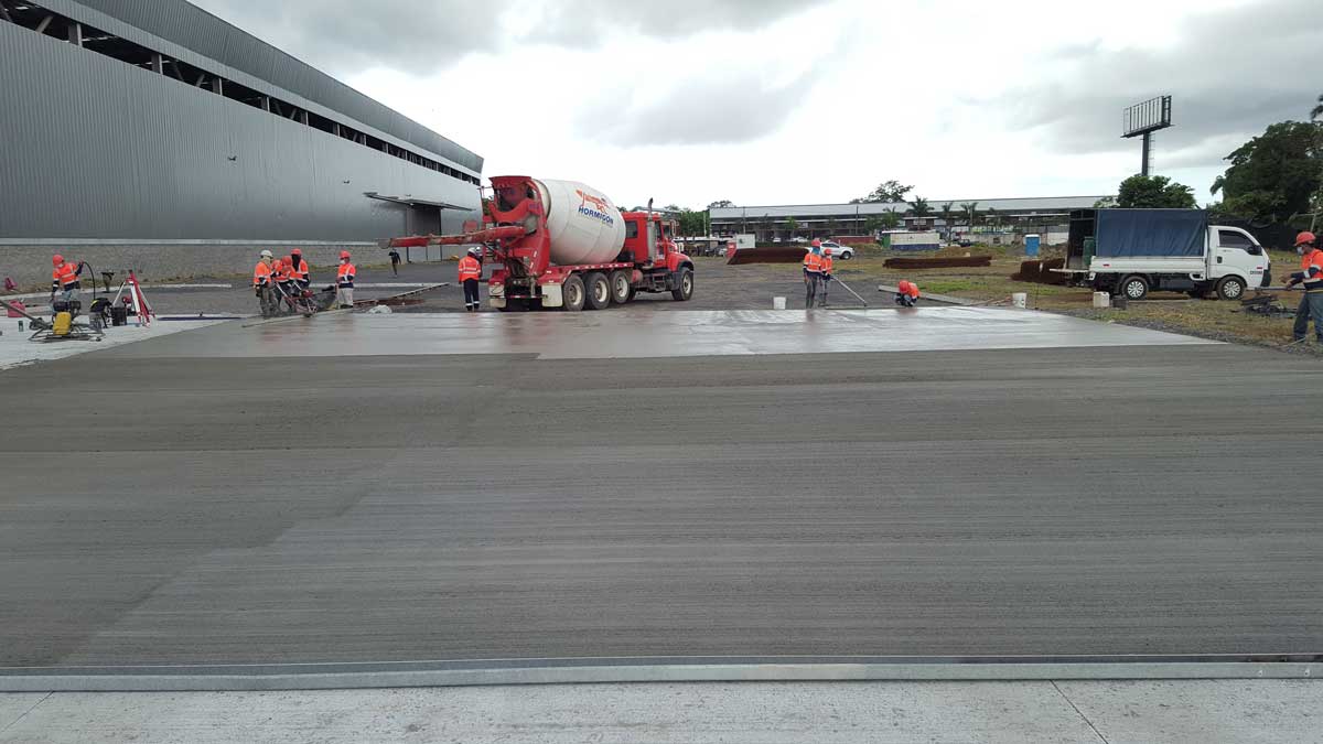 Piso industrial de concreto para Grupo Metales en La Chorrera, Panamá. Trabajadores vaciando el hormigón para la ofibodega.