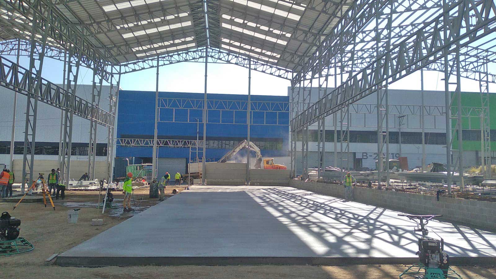 Inicio del vaciado de losa de concreto para piso industrial en bodega de Grupo Macro, Guatemala. Equipo de CCM nivelando el hormigón.