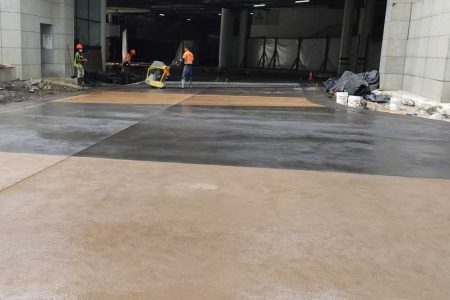 Instalación de piso de concreto con color integrado bicolor (gris y terracota) en área de circulación exterior. Servicio de pavimentación decorativa por CCM.