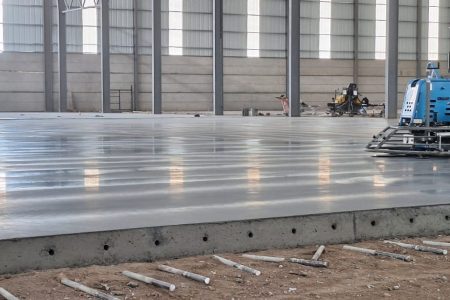 Acabado de piso industrial de concreto con allanadora mecánica en las Bodegas de Cuenca, Guatemala. Superficie de alta planitud.