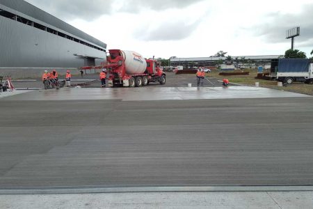 Piso industrial de concreto para Grupo Metales en La Chorrera, Panamá. Trabajadores vaciando el hormigón para la ofibodega.